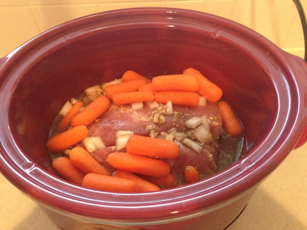 pork loin and carrots in a crock pot before cooking