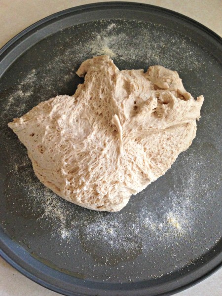 pizza dough turned out onto prepared pizza pan