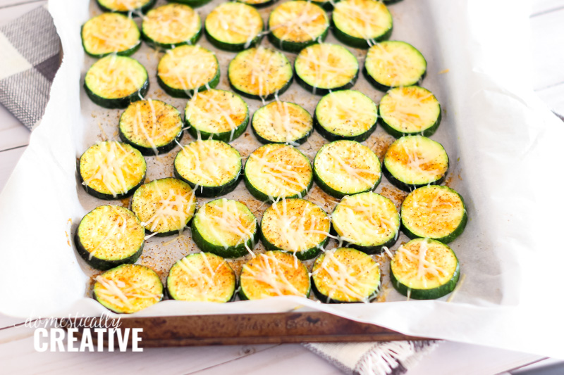 Oven roasted zucchini slices on a sheet pan, perfectly cooked.