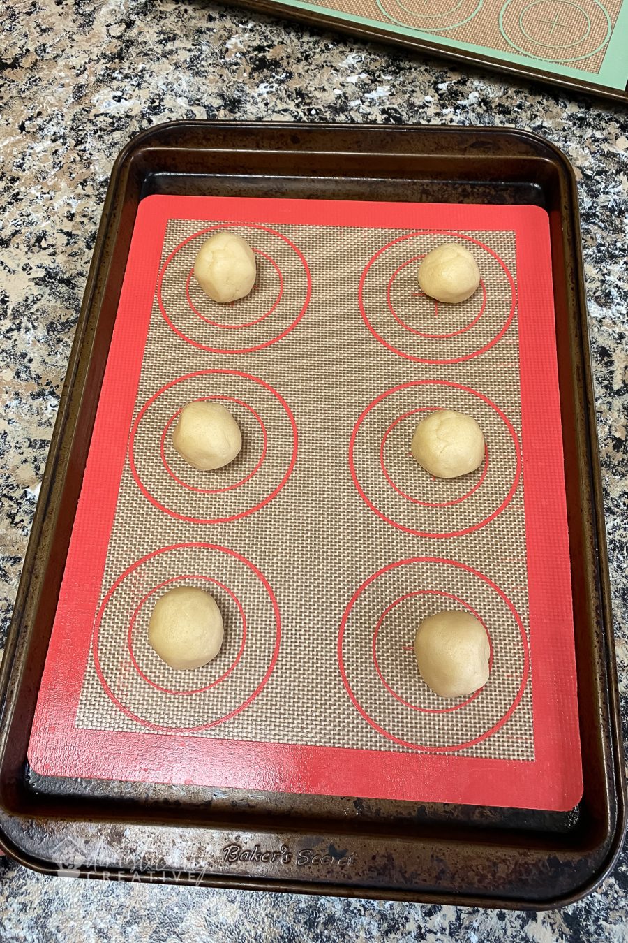 balls of sugar cookie dough on baking sheet ready for baking