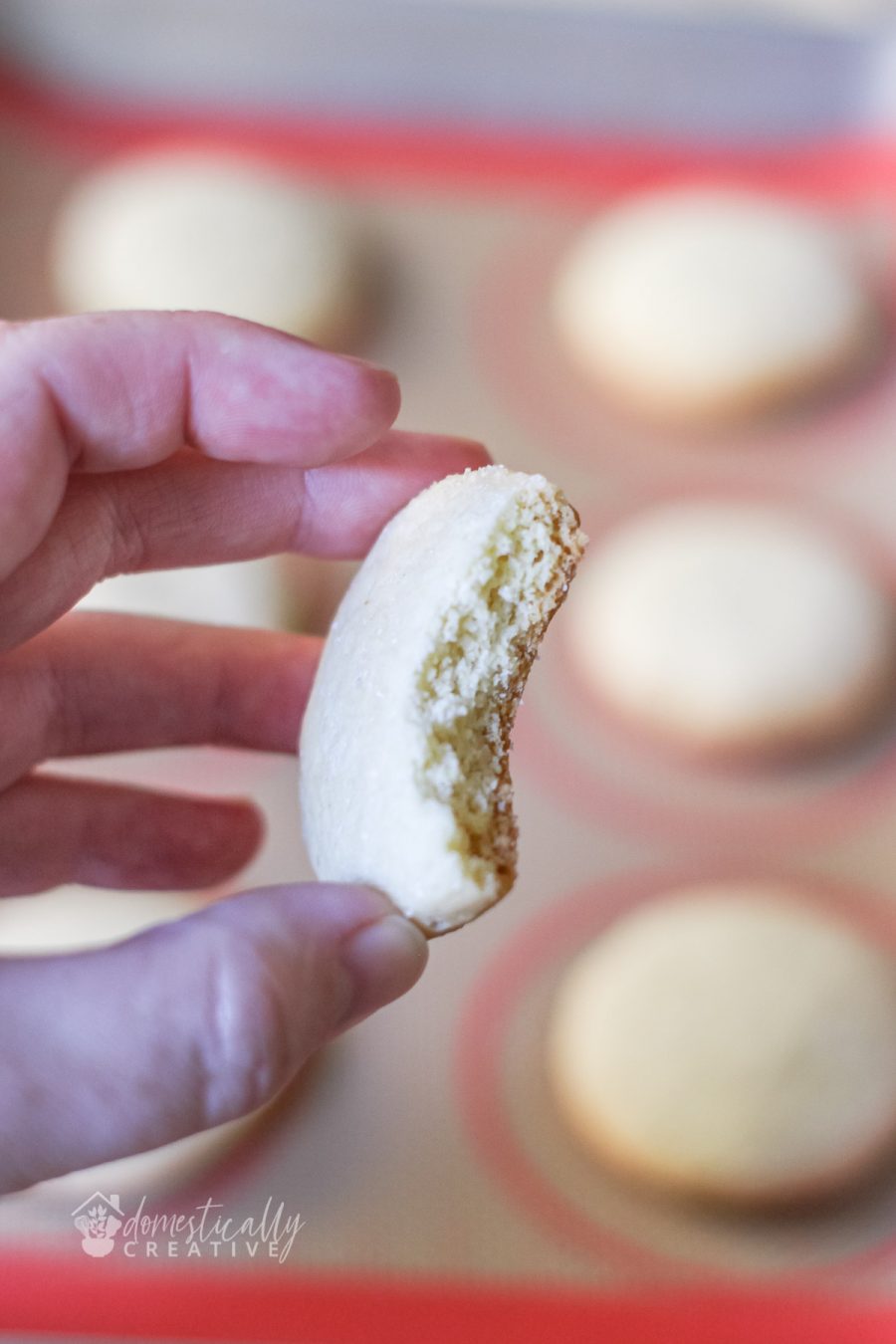 Hand holding drop sugar cookie broken in half