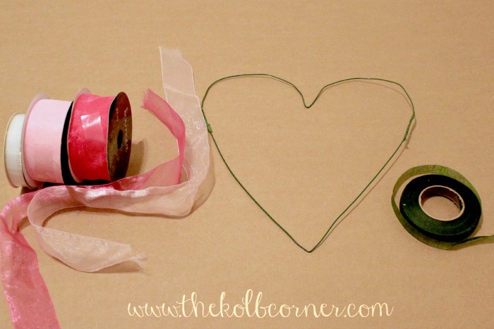 Wire heart wreath, floral tape and tulle ribbon on cardboard background
