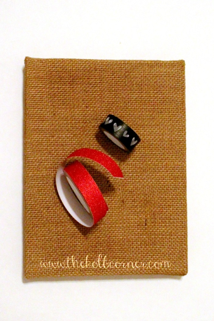 Burlap canvas on white background with black and white heart washi tape and glittery red washi tape on top.