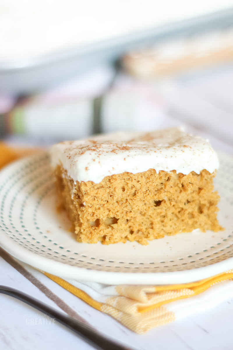 Close up of cream cheese frosted pumpkin bar with yellow checked napkin