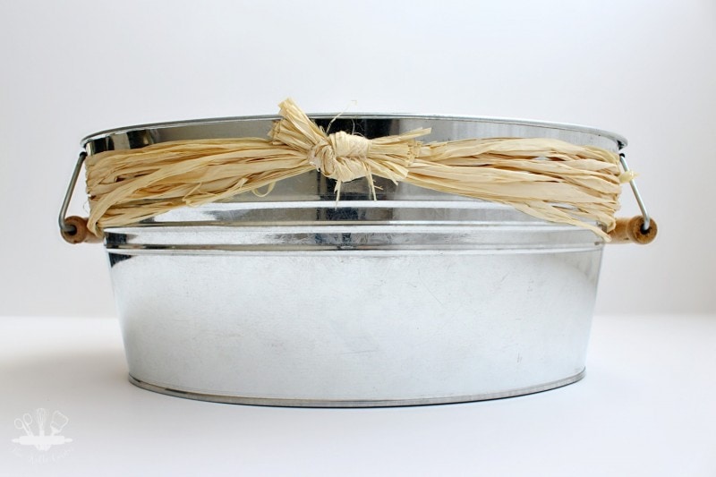 Galvanized bucket with raffia ribbon tied on