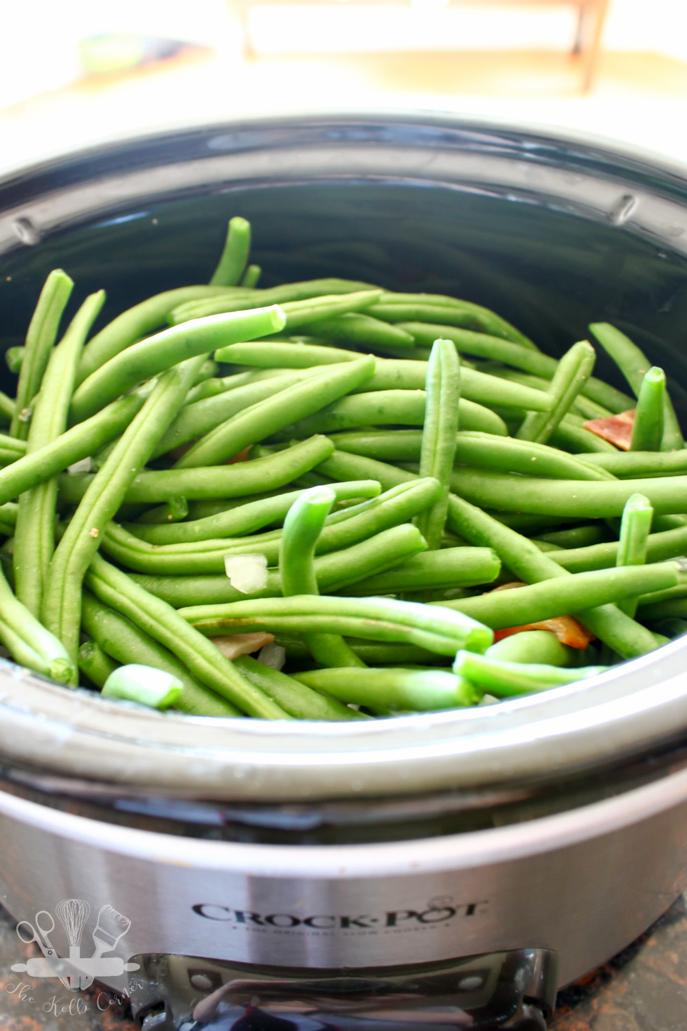 fresh green beans in the bowl of a Crock Pot