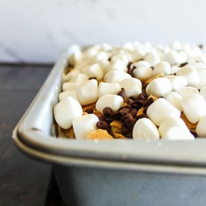 Delicious and incredibly easy to make S'mores Poke Cake. Bring the campfire experience home with this simple to recreate recipe.