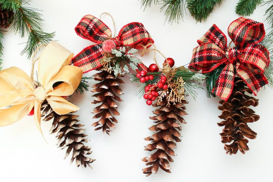 4 pine cone ornaments laying flat on a white background