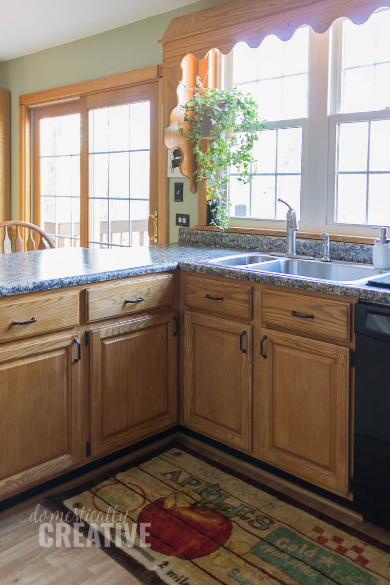 kitchen counters and cabinets with sliding glass door and big window over sink