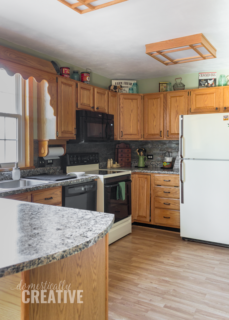 full photo of kitchen with oak cabinets, painted granite counters and old appliances