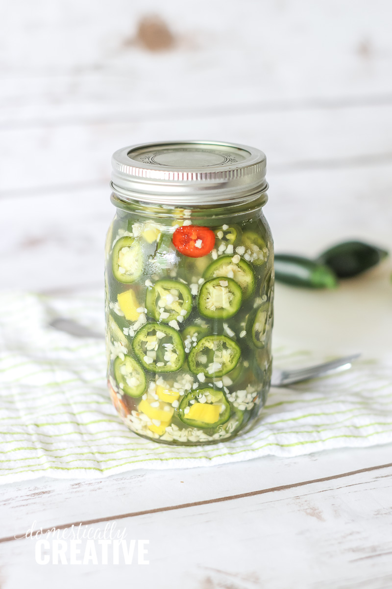 close up of mason jar packed with jalapenos