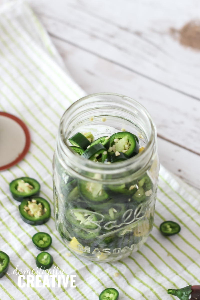 mason jar half filled with jalapeno slices