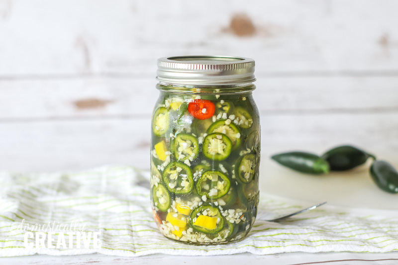 close up of mason jar packed with jalapeno pickles