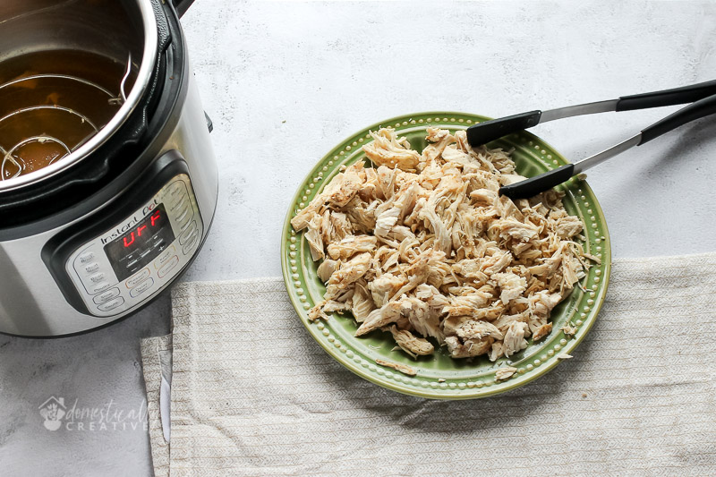 shredded chicken on a plate with instant pot in background
