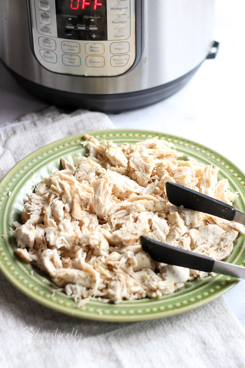shredded chicken on a plate with instant pot in background