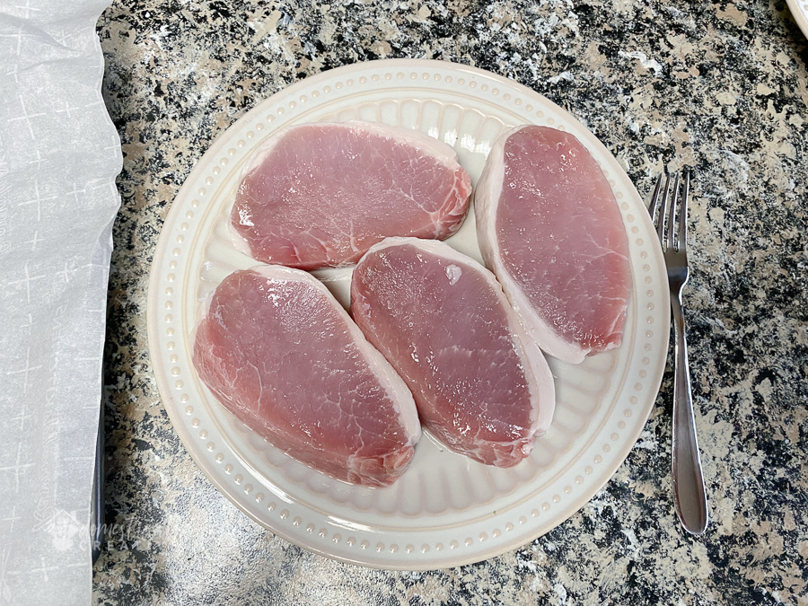 boneless loin pork chops on a plate not cooked